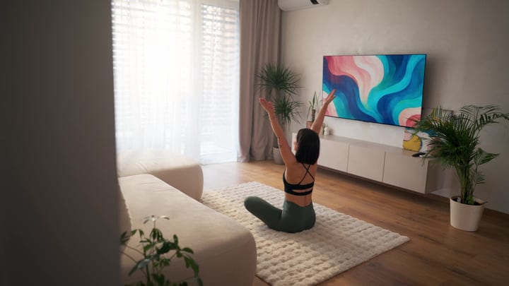 Woman Practicing Yoga Pose On Rug In Her Modern Living Room