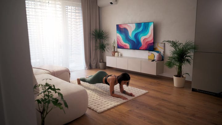 Woman Holds Plank Pose On Rug In Bright Modern Living Room