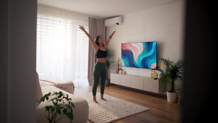 Young Woman Stretching Arms Upwards In Her Bright Modern Living Room