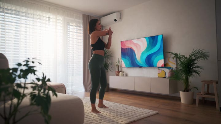 A Woman Gently Stretches Her Shoulders In A Sunlit European Apartment