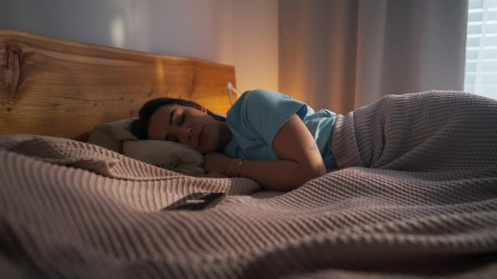 Young Woman Sleeping Peacefully In Her Bed During Morning Light