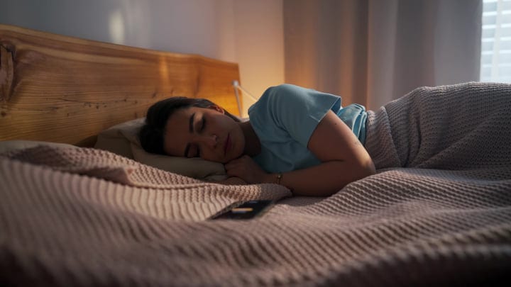 Young Woman Sleeps Soundly In Her Cozy Bed With Soft Morning Light
