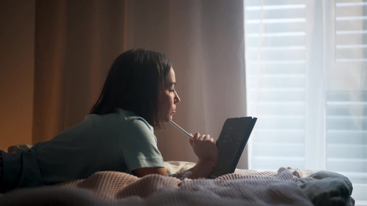 Young Woman Working Creatively On Digital Tablet In Her Cozy Bedroom