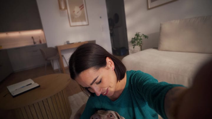 Young Woman Smiling At Her Puppy In A Warm, Modern Living Room