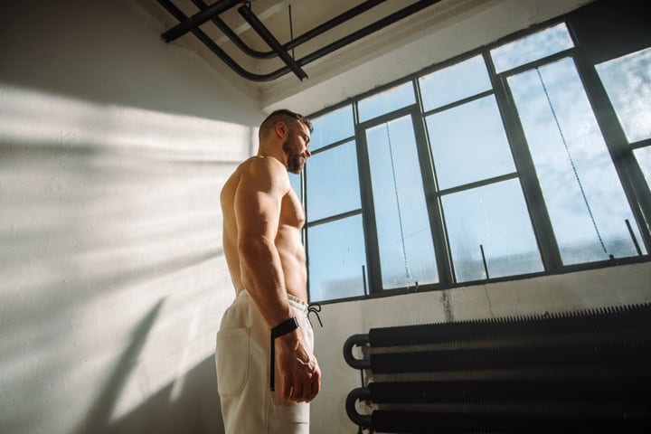 Yogi Man Pausing Indoors By Large Window With Strong Daylight
