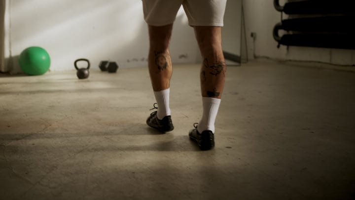 Close Up Of Tattooed Legs And Feet Walking In An Indoor Fitness Studio