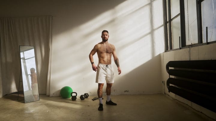 Shirtless Man Standing In Indoor Gym Studio By Window Light