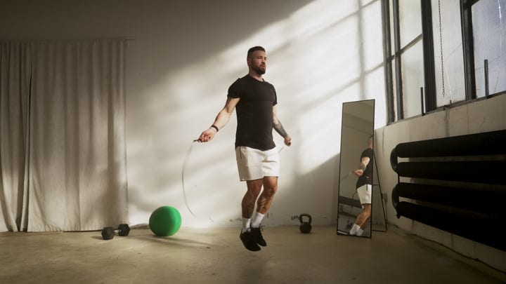Man Jumping Rope During Morning Workout In Minimalist Home Gym Studio