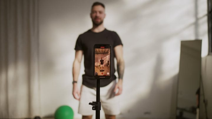 Male Yogi Records Indoor Fitness Session With Smartphone On Tripod