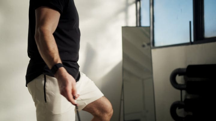 Man Practicing Yoga Indoors By A Window With Natural Light During His Workout