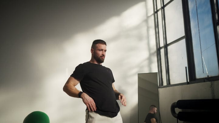 Bearded Man Adjusting His Athletic Wear In A Bright Gym Interior