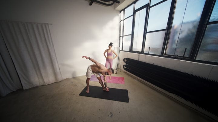 Man And Woman Practice Yoga Together In Bright Industrial Studio