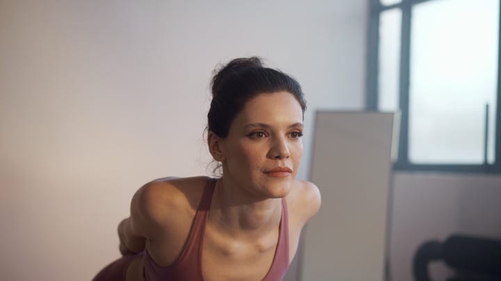 A Woman Focuses On Her Yoga Practice During An Indoor Wellness Session