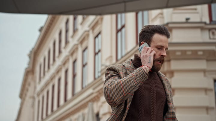 Confident Businessman Navigates Urban Streets on a Call