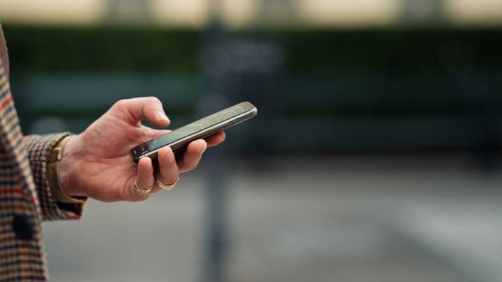 Stylish Businessman Navigates the City With Smartphone
