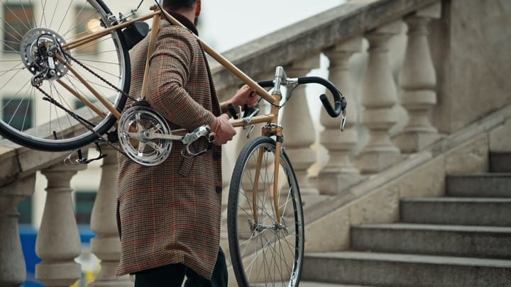 Businessman Carries Bicycle Up Stone Steps In Autumn