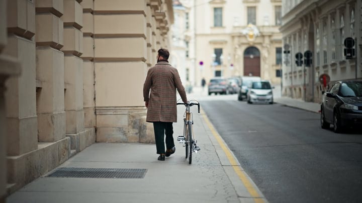 Businessman Strolls With Bicycle On European Street