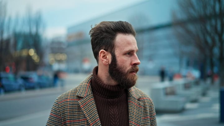 Contemplative Businessman Strolling Through Winter Cityscape