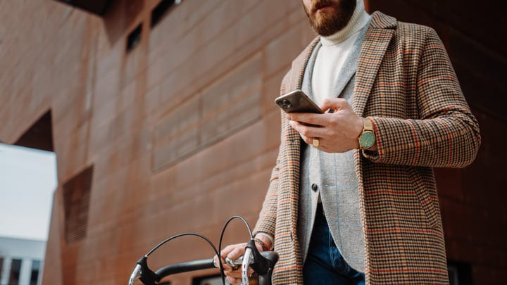 Businessman Checks Phone During Urban Bicycle Commute