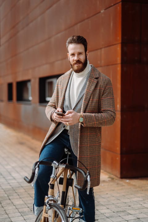 Confident Businessman Checks Phone on Urban Commute