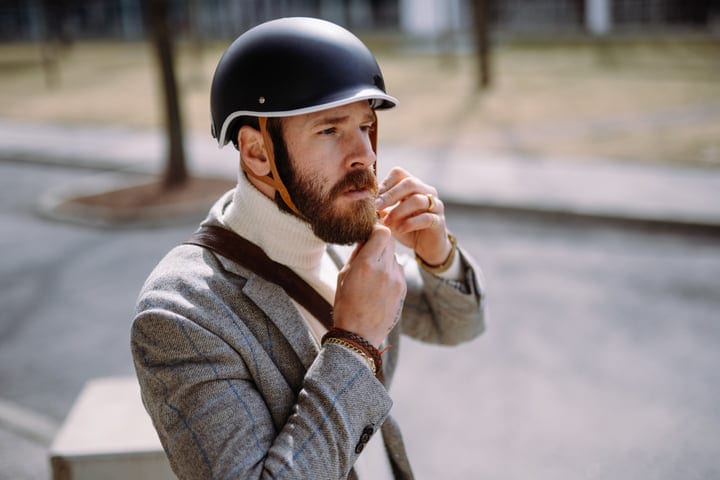 Modern Commuter Fastens Helmet In Urban Setting