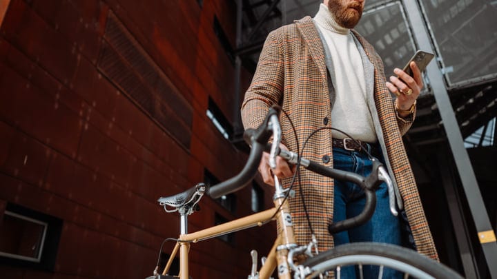 Businessman Checks Smartphone During Bicycle Commute