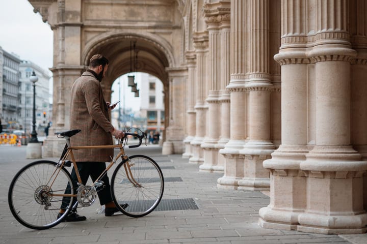 Businessman Pauses With Bicycle In Historic European City