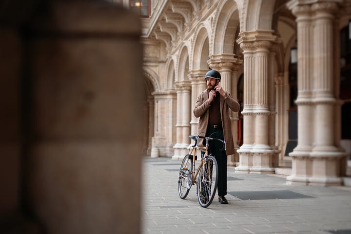 Businessman Adjusts Helmet Ready For Urban Bicycle Commute