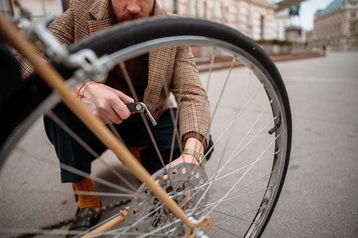 Businessman Repairing Bicycle Wheel During Urban Commute