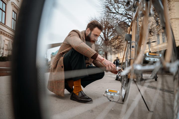 Businessman Adjusts His Bicycle In Urban Cityscape