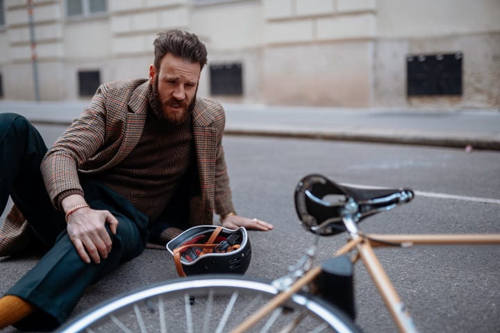 Urban Businessman Pauses After Unexpected Bicycle Mishap