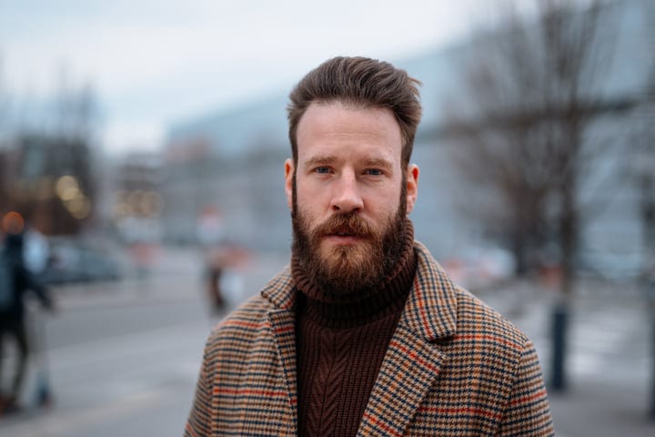 A Bearded Businessman Faces The Urban Chill Of Winter