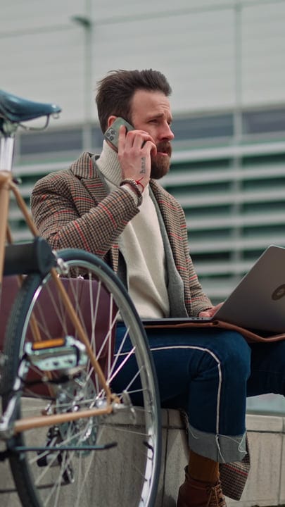 Businessman Balances Urban Commute With Laptop And Phone