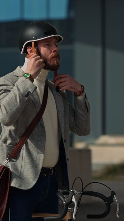 Urban Commuter Adjusts Helmet Under Morning Sun