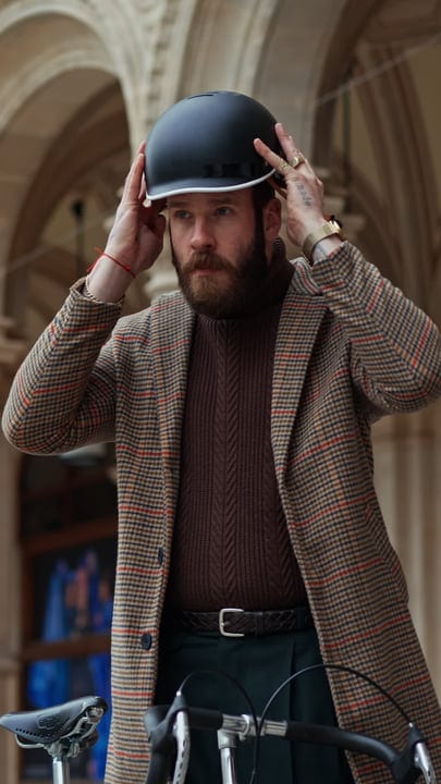 Urban Cyclist Adjusts Helmet Amidst Architectural Beauty