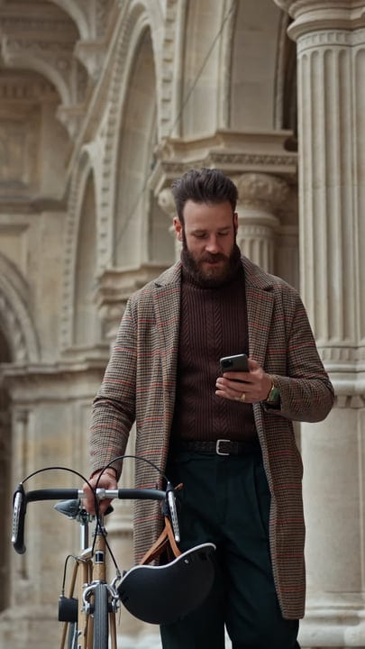 Businessman Cyclist Checking Phone in Urban Archway