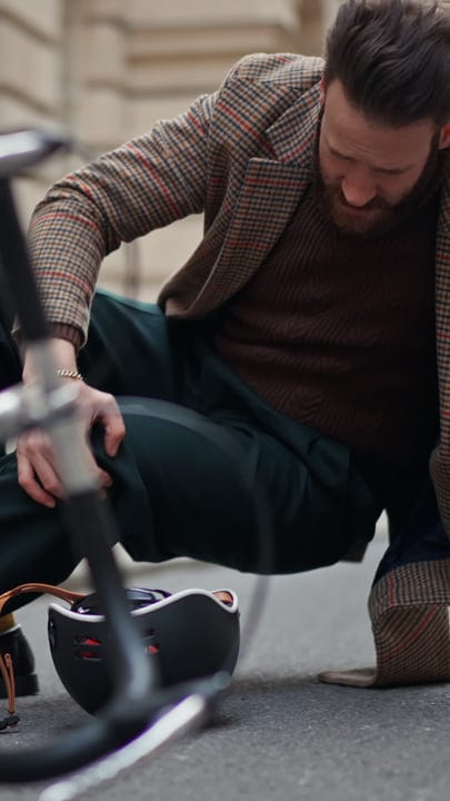 Businessman In Tweed Jacket Adjusts Bicycle Helmet In City