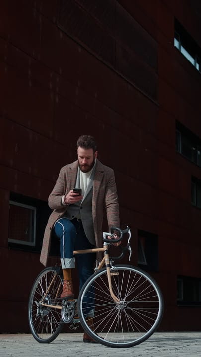Businessman Checks His Phone During Urban Bicycle Commute