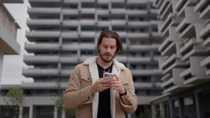 Businessman Checks Phone Amid Urban Architecture