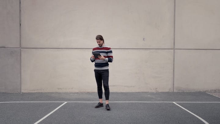 Focused Businessman Engages With Tablet On Urban Stroll