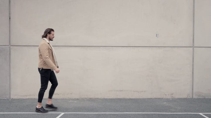 Confident Businessman Strolls Along Urban Concrete Wall
