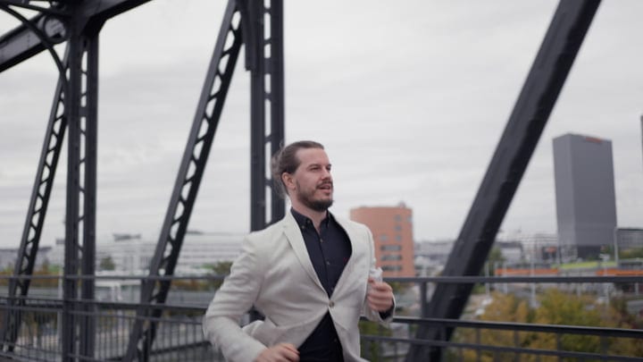 Confident Businessman Walking Across Urban Bridge