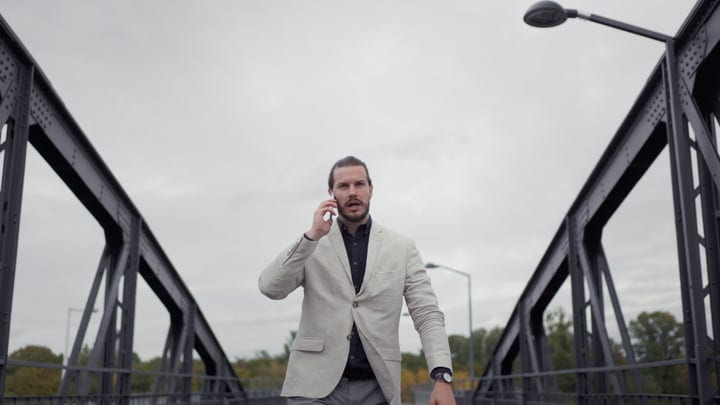 Confident Businessman Takes a Call on Urban Bridge