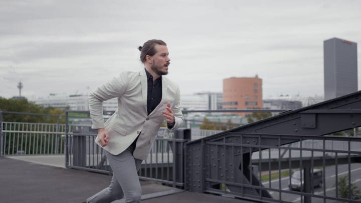 Determined Businessman Sprints Across Urban Bridge at Dusk
