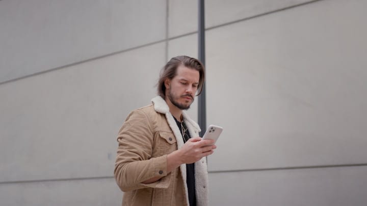 Modern Businessman Engaged With Smartphone Outdoors