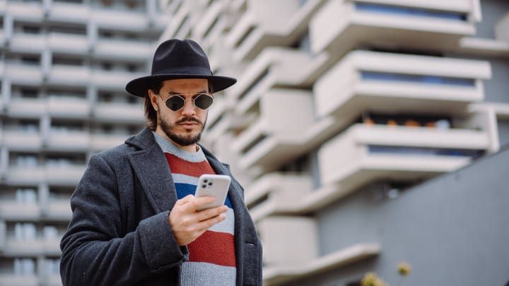 Stylish Businessman Engages With His Smartphone On City Walk
