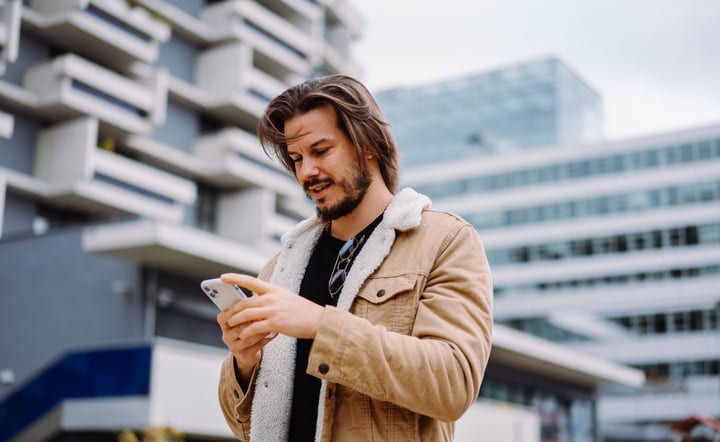 Confident Businessman Checking Phone in Urban Setting