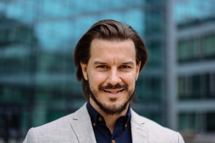 Confident Businessman Smiling Against Modern Urban Backdrop