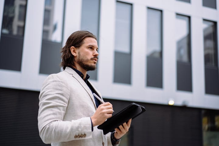 Confident Businessman Navigates Urban Environment With Tablet