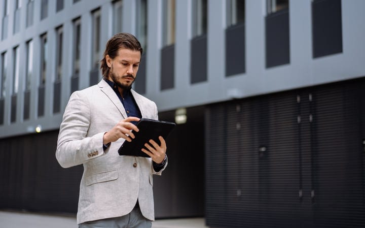 Thoughtful Businessman Engages With Technology On City Walk